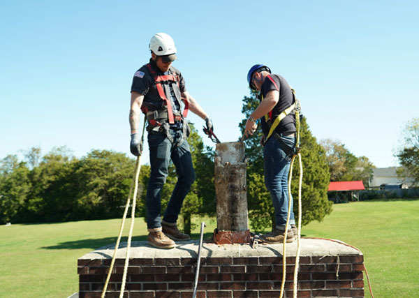 Two Technician on Roof Fixing Chimney
